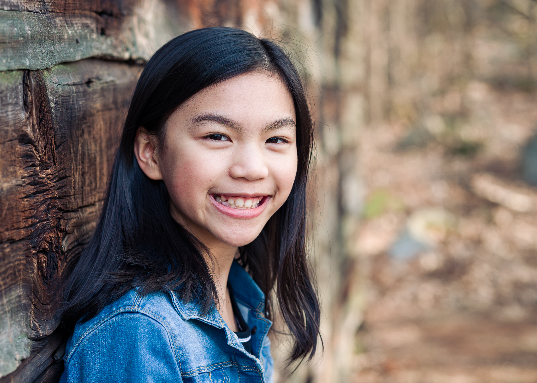 Young girl leaning against wooden wall at Wayside Inn Grist Mill, Sudbury MA