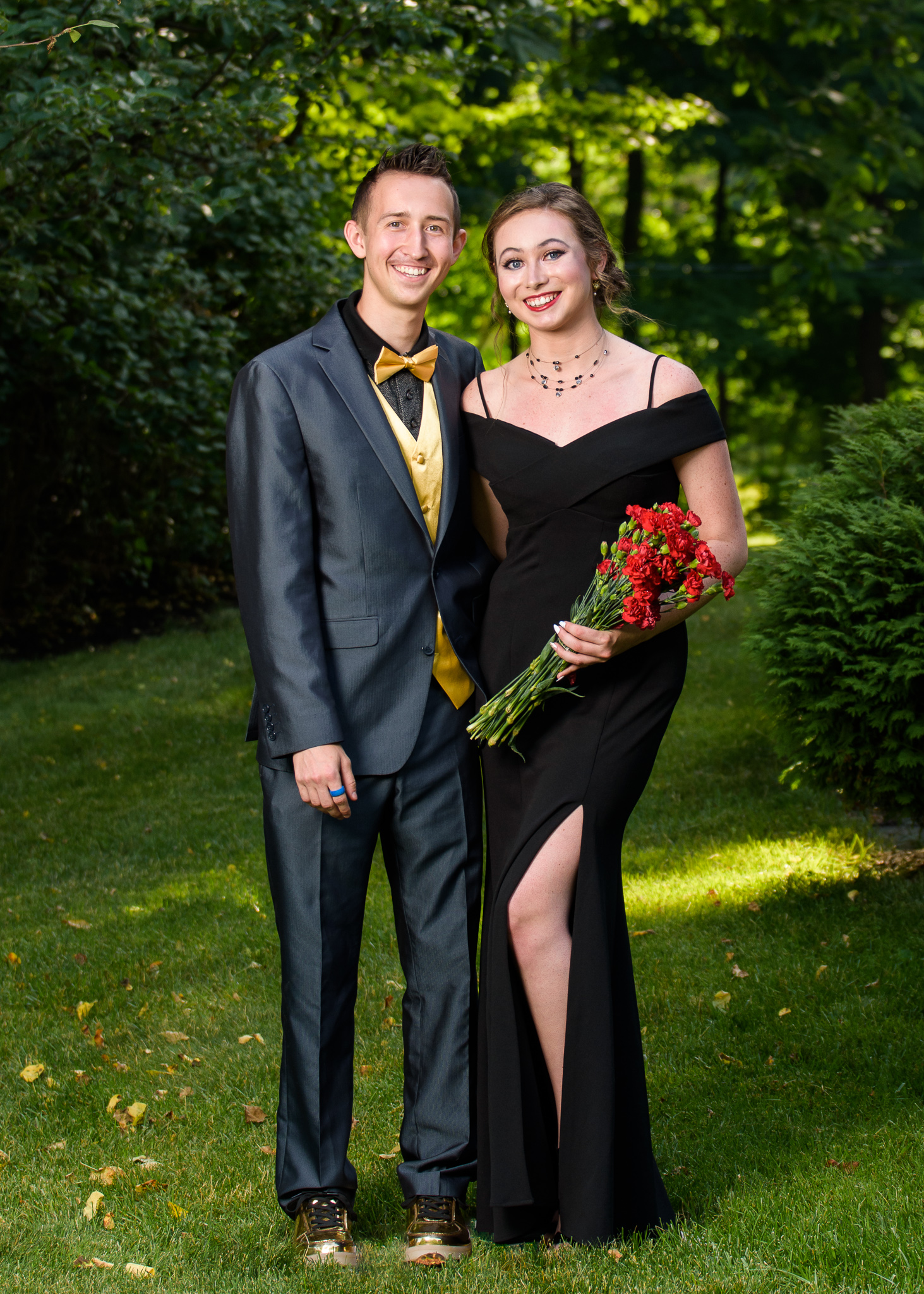 Couple in formal wear holding red roses on a lawn, prom portrait at a client's home in Shrewsbury, MA